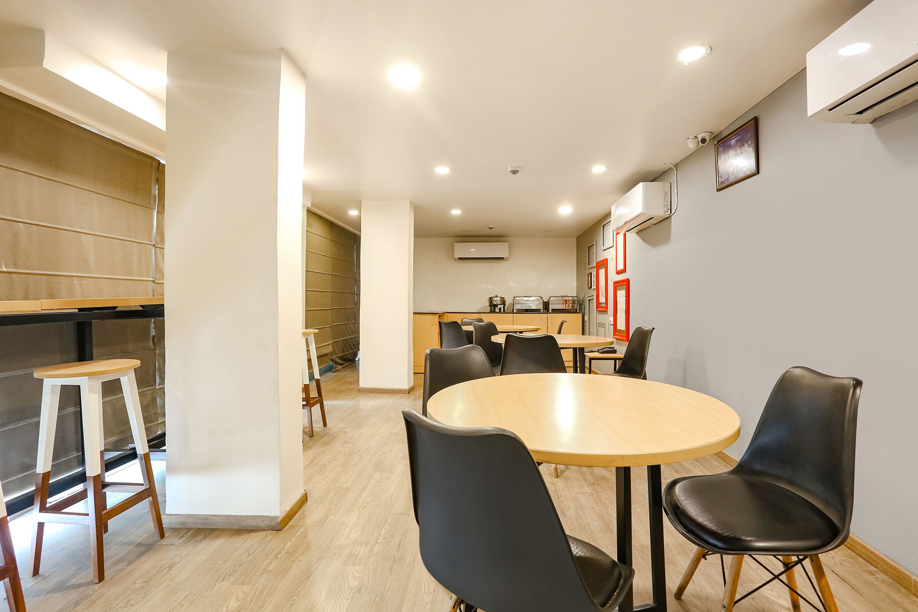 A modern kitchen with a dining area featuring a round table and black chairs.