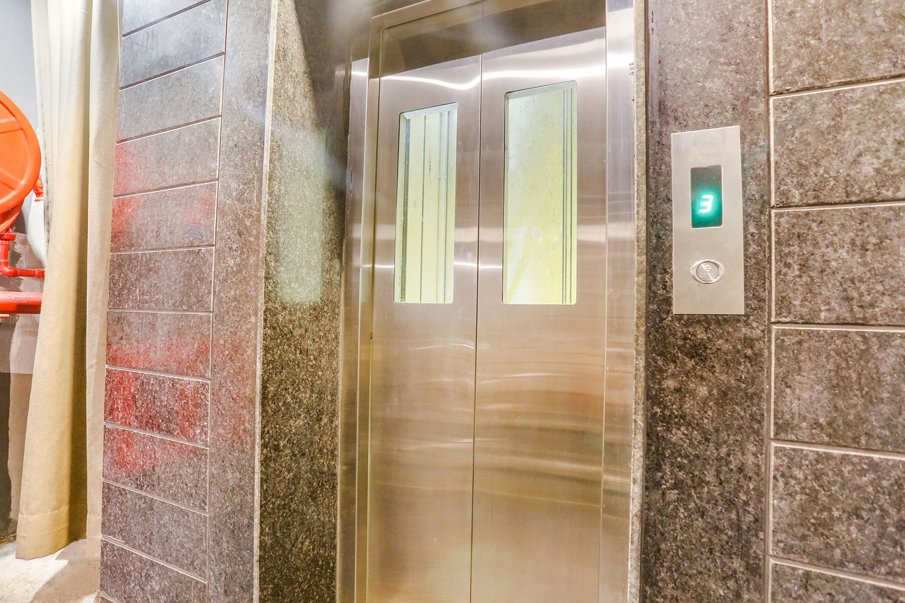 An elevator with a digital display and a metallic door.