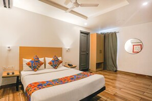 Relax in a cozy space with a neatly made bed, wooden headboard, and a bedside table with a lamp.