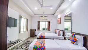 A hotel room with two beds, a flat-screen TV, an air conditioning unit, and a ceiling fan. - Fabhotel Rani Tower (Barasat)