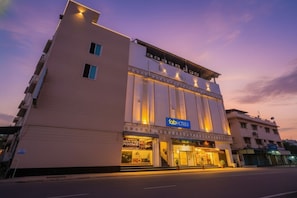 A modern building with a 'fab hotels' sign, featuring a large entrance and multiple windows.