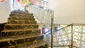 A marble staircase with geometric patterned railings. - FabExpress Corinthia Boutique Rooms, Candolim Beach (Candolim)