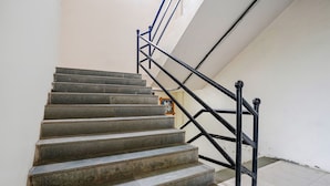 Eine Treppe mit schwarzen Geländern und einem gefliesten Boden.