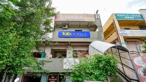 Ein Gebäude mit Schildern für Swara Residency, Fab Hotels und Nisislg Lodge.