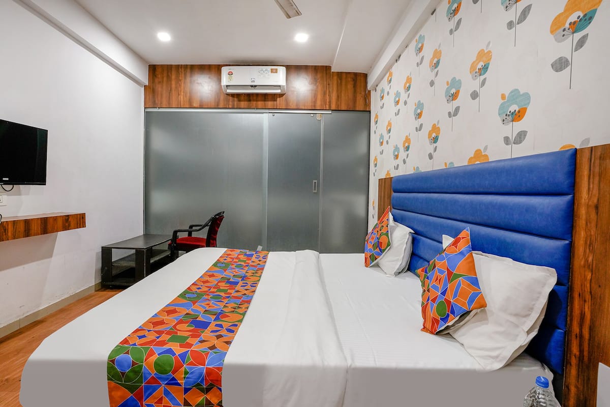 A hotel room with a bed, a TV, a wardrobe, and a bathroom.