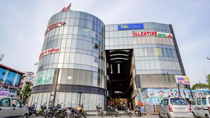 Un edificio moderno con fachada curva, que muestra letreros de 'The Valentine Hotel' y 'Fab Hotels'.