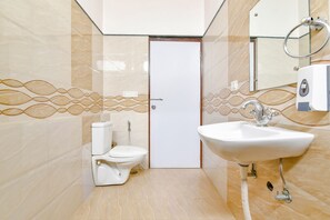 Un baño con inodoro, lavabo y espejo.