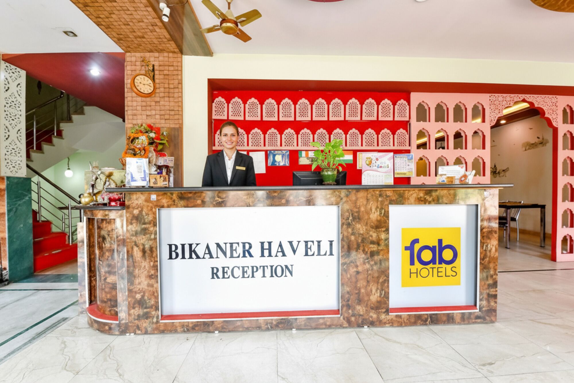 A reception desk with a sign reading "Bikaner Haveli Reception" and "Fab Hotels".