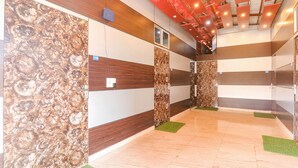 A hotel corridor with wooden panel walls, a tiled floor, and a ceiling with red lighting. - Fabexpress Atithi (Nagri)