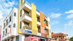 A multi-story hotel with balconies, a visible sign for 'Hotel Stay Bridge', and a clear blue sky in the background. - Hotel Staybizz by Keymagics (Jaipur)
