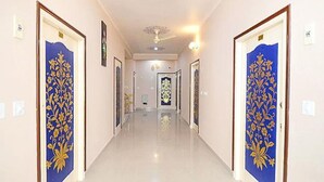 A hallway with two doors on either side, each with a floral design. - Hotel Staybizz by Keymagics (Jaipur)
