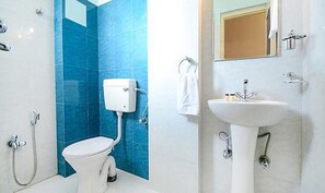 A bathroom with a toilet, a sink, and a shower. - Hotel Staybizz by Keymagics (Jaipur)