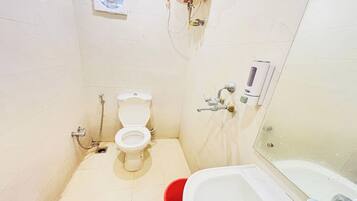 A small bathroom with a toilet, a shower, and a bathtub.