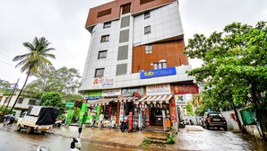 Un edificio de varios pisos con un letrero de 'fab hotels', un letrero de 'freebo' y un letrero de 'Dr. Fike'.