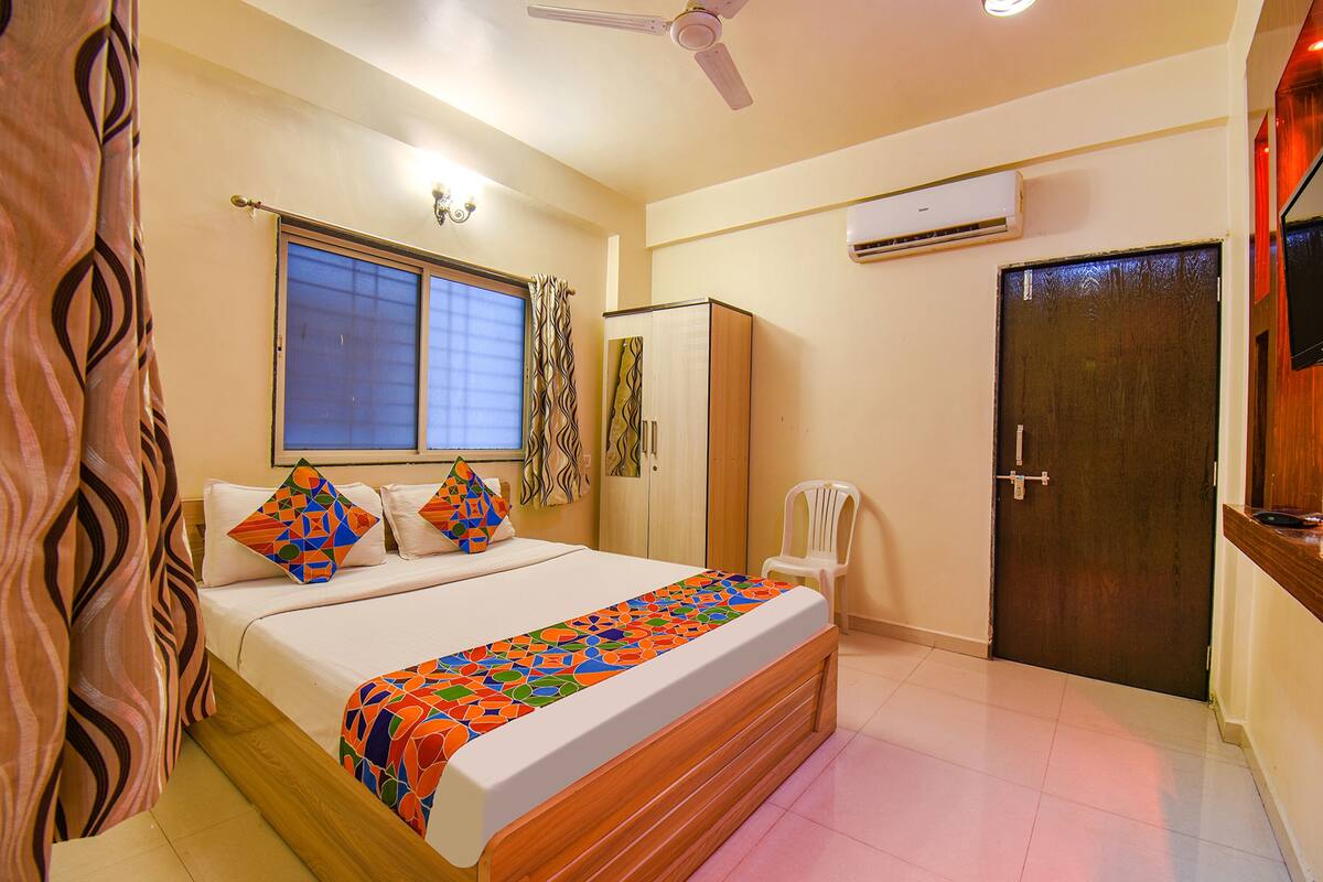 Quarto com cama, janela, ar condicionado e porta.