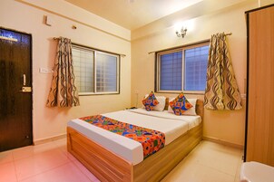 Un dormitorio con cama, cortinas, ventana y puerta.