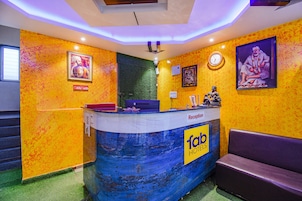 Una mesa de recepción con un letrero de 'fab hotels', un reloj y cuadros en las paredes.