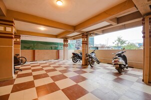 Un suelo a cuadros, dos motocicletas, una bicicleta y una pared verde con una ventana.