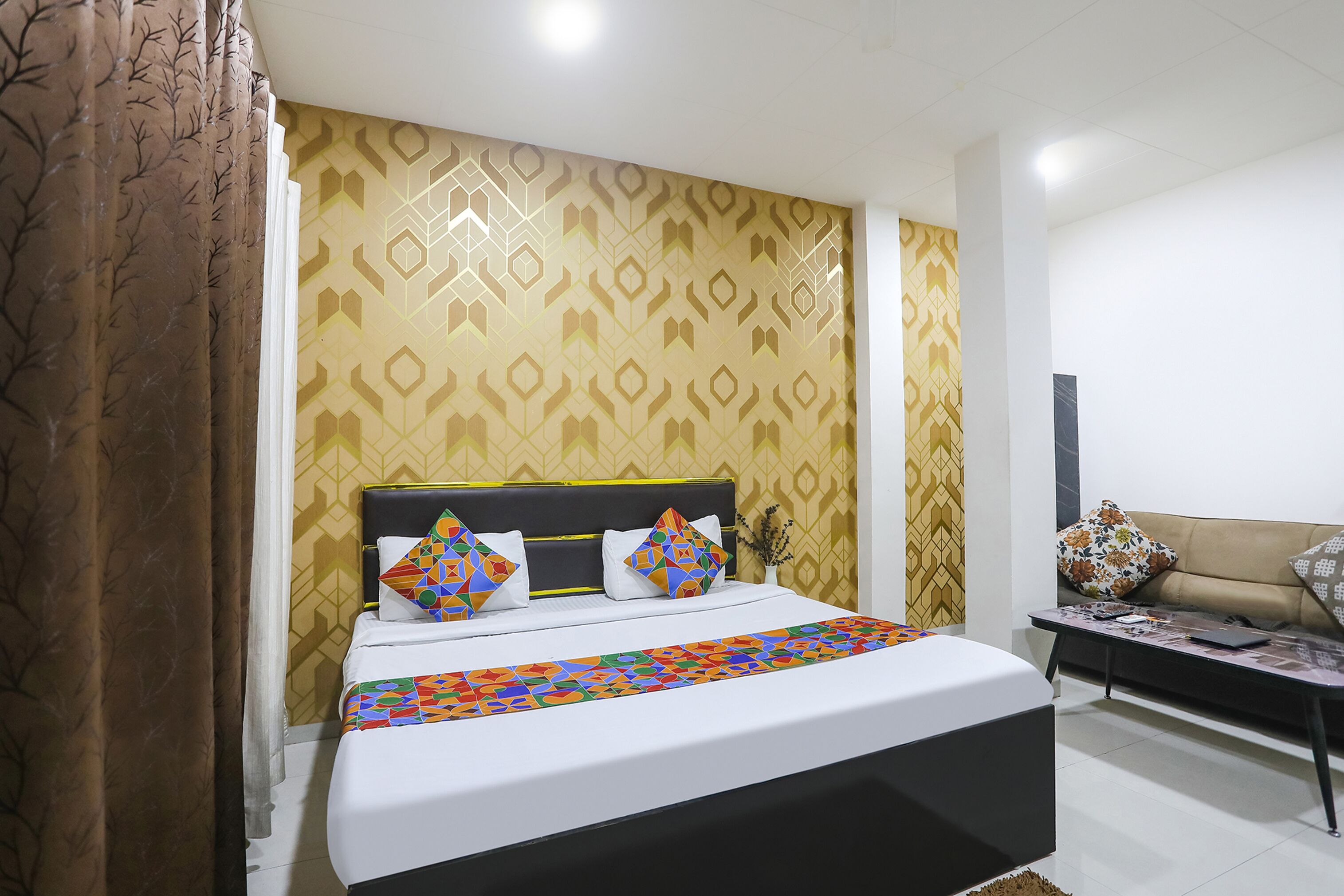 A neatly made bed with a patterned bedspread, a headboard, and decorative pillows.