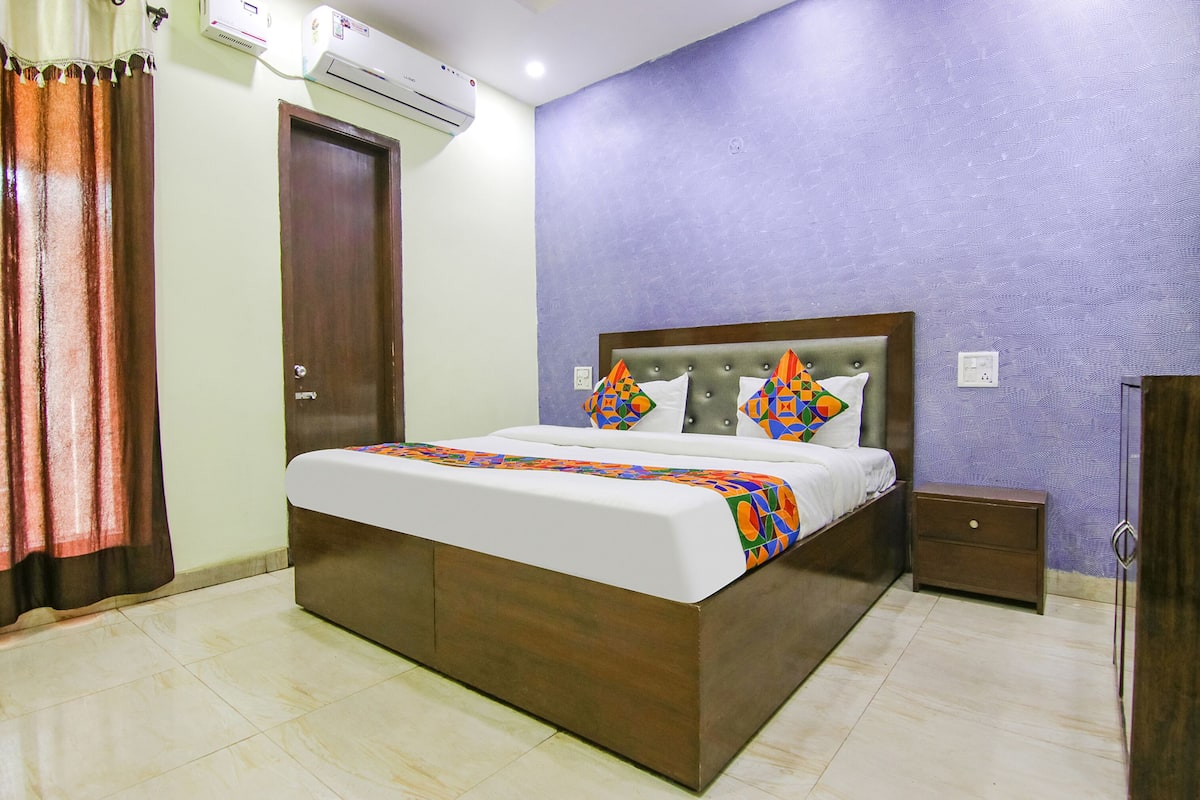 Une chambre à coucher comprenant un lit, une table de chevet, une armoire et un appareil de climatisation.