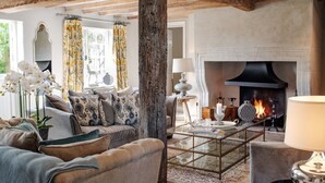 Una sala de estar acogedora con chimenea, asientos cómodos y detalles decorativos.