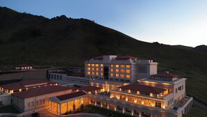 A large, multi-story hotel with a central courtyard, surrounded by a hilly landscape. - Ayan Zalaat (Ulaanbaatar)