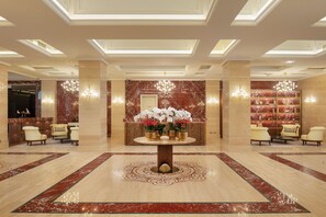 A lobby with a central round table, seating area, and a reception desk. - Ayan Zalaat (Ulaanbaatar)