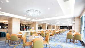 A spacious banquet hall with multiple tables and chairs, a bar area, and a chandelier. - Langson Dongguan - Dalang Songshan Lake (Dongguan)