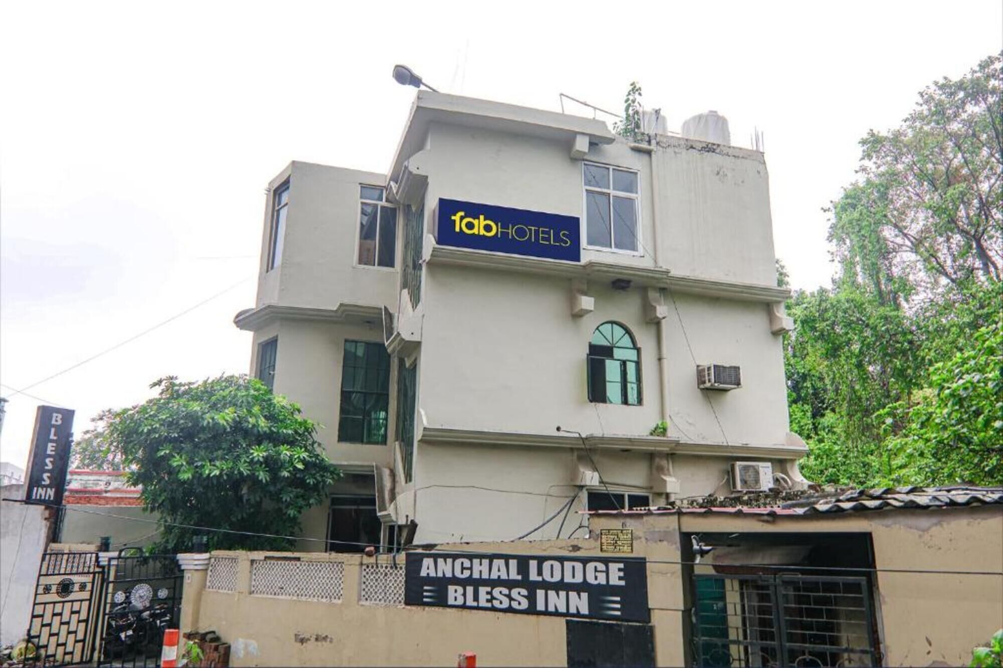 A building with a sign for 'Tab Hotels' and another sign for 'Anchal Lodge Bliss Inn.'