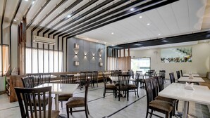 A spacious restaurant with high ceilings, modern lighting, and a mix of seating arrangements including tables and booths. - Fabhotel Heritage Palace (Chhatrapati Sambhajinagar)