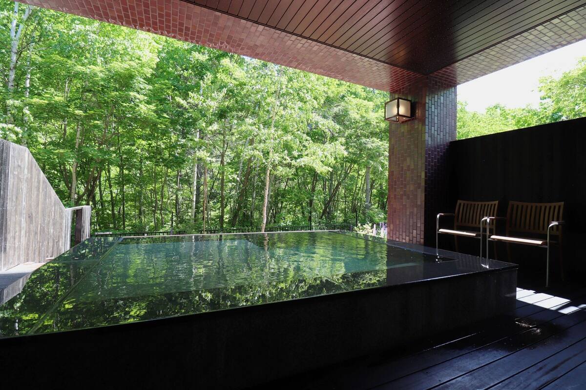 A hot tub with a view of a forest.