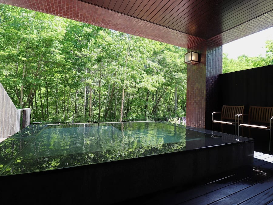 A hot tub with a view of a forest.