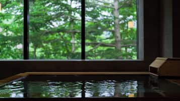 A room with a large window, a wooden bench, and a small wooden structure.