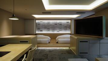 A modern bedroom with a large bed, a desk, a chair, a TV, and a window with frosted glass.