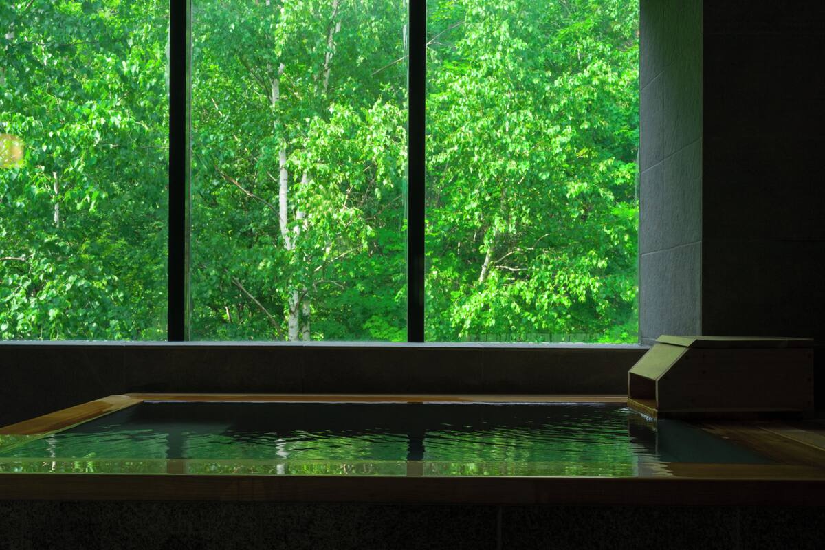A spa area with a large window overlooking a dense forest.