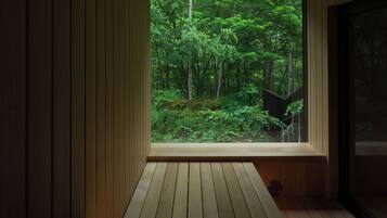 Una habitación con un ventanal grande que da a un bosque.
