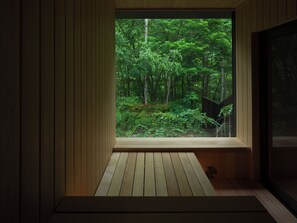 Una habitación con un ventanal grande que da a un bosque.