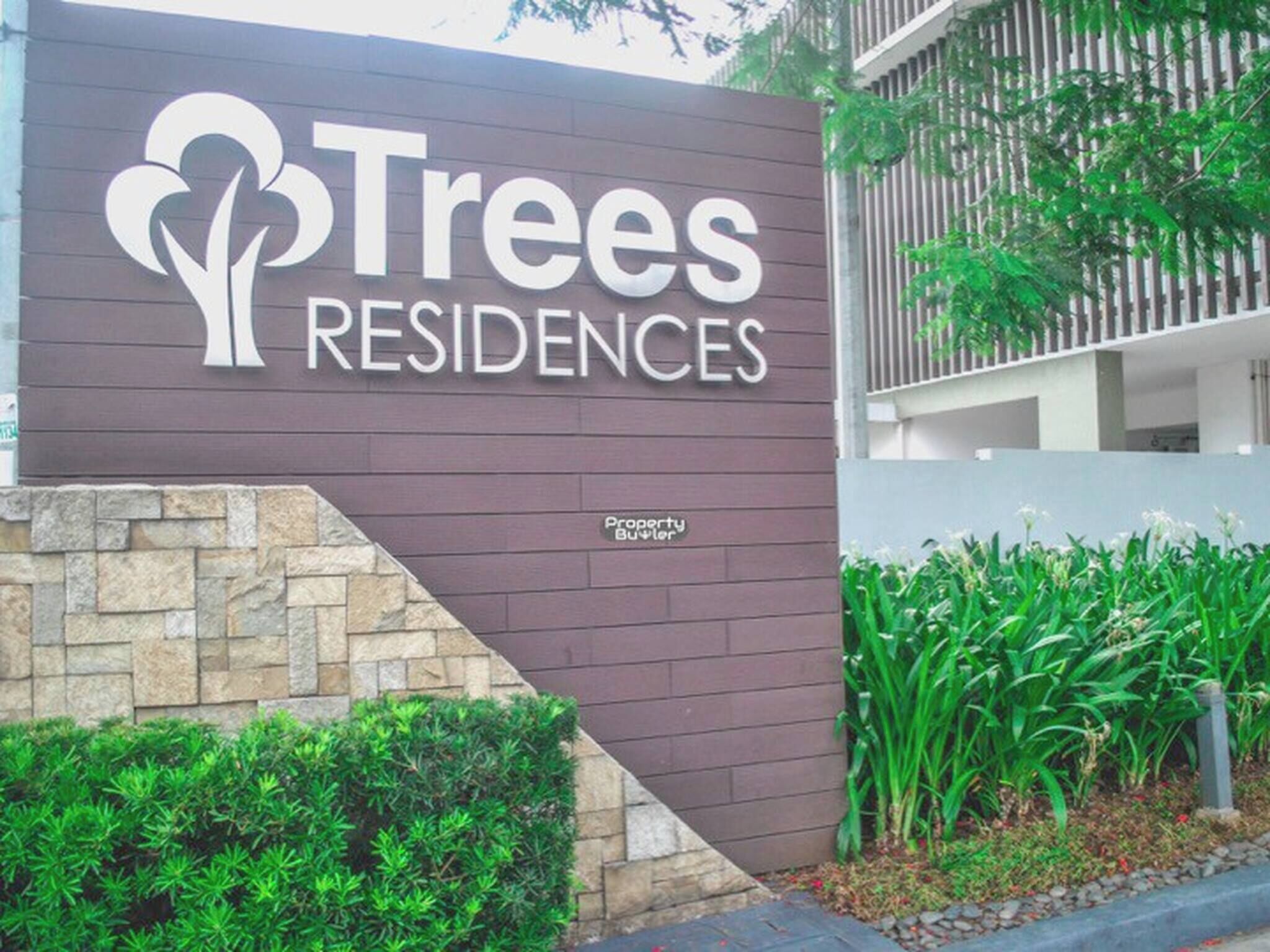 Un letrero para Trees Residences con un logotipo de árboles estilizados y el texto 'Trees Residences'.