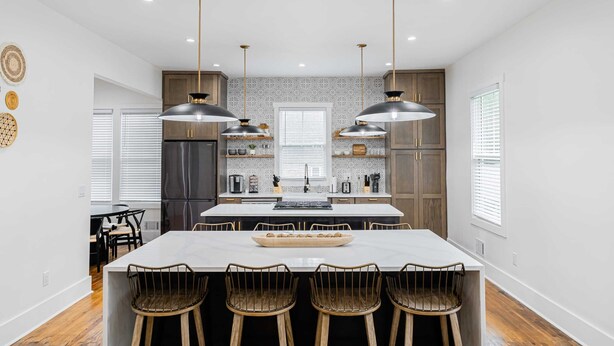 A modern kitchen with a central island, pendant lighting, and wooden cabinetry. - Historic Gem in the Heart of Norcross (Norcross)