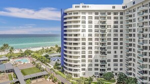 Un hôtel de grande hauteur doté de nombreux balcons, d’un espace piscine et offrant une vue sur la plage.