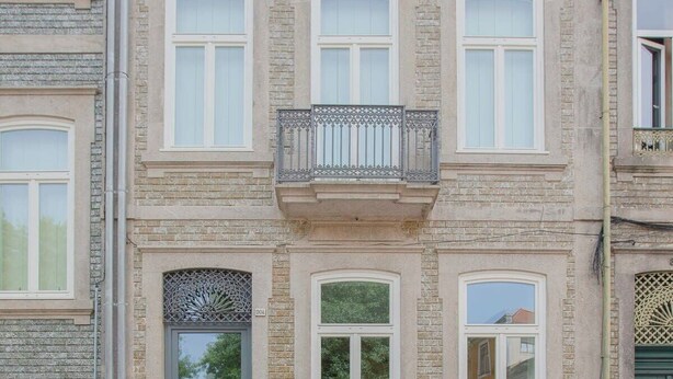 A two-story building with a balcony, a grey door, and multiple windows. - Liiiving in Porto - Haven Pool Apartment (Porto)