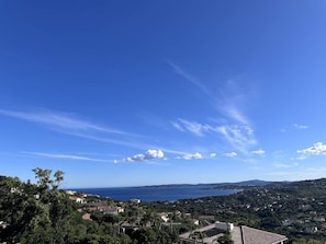 En kystby med klart himmel, huse og havudsigt.