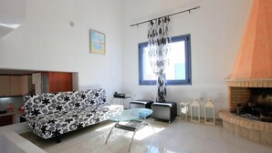 Ein modernes Wohnzimmer mit einer Couch, einem Glastisch und einem Kamin.