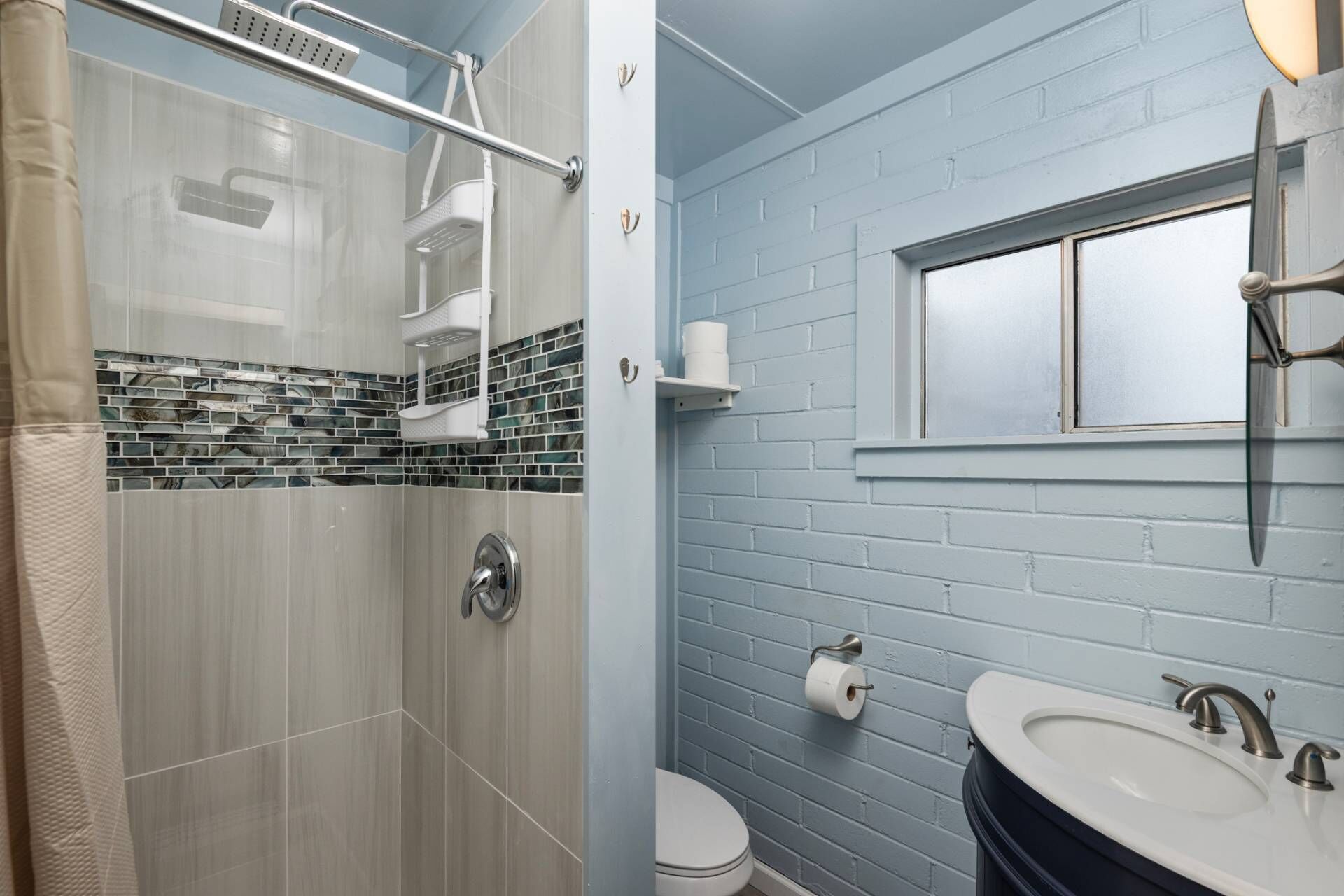 A bathroom with a shower, toilet, and sink.