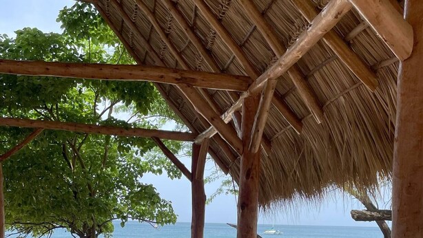 A wooden deck with a thatched roof, overlooking a beach with a clear view of the ocean. - Ocean/Beachfront Living ~Rustic Fishing Village w/Upscale Amenities HAVE IT ALL! (El Gigante (Playa Gigante), Tola)