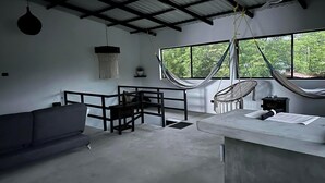 A modern interior with a sofa, a dining table, and two hammocks. - Ocean/Beachfront Living ~Rustic Fishing Village w/Upscale Amenities HAVE IT ALL! (El Gigante (Playa Gigante), Tola)