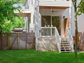 A house with a covered porch, a wooden fence, and a well-maintained lawn.