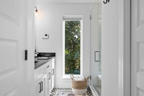 A narrow hallway with a window, a basket, and a door.