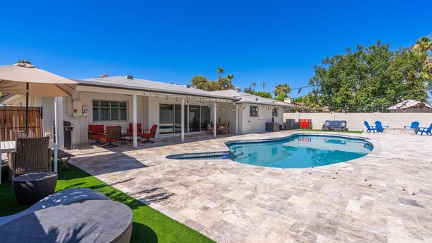 A backyard with a swimming pool, outdoor furniture, and a covered patio area. - Luxurious Cascada Oasis ~ Cozy ~ Games ~ King Beds (Litchfield Park)