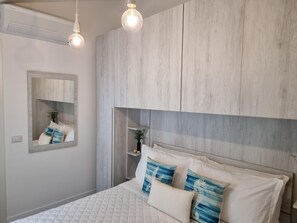 Un dormitorio con cama, espejo y paneles de madera en la pared.